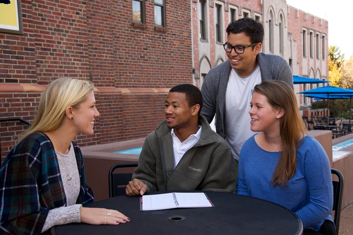 4 Exterior Group Outside Sitting SLU Smiling Standing Students 24961